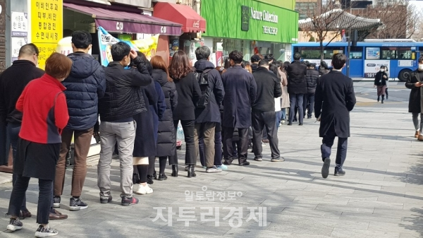 13일 오후 1시40분 서울 광화문 사거리의 한 약국 앞. 오후 2시부터 마스크를 판매하는 이 약국 앞에 마스크를 구매하려는 사람들이 줄지어 서 있다.