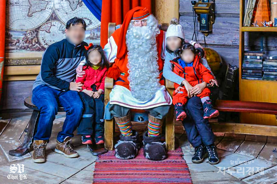 로바니에미 외곽에 위치한 산타클로스 마을 본관에 위치한 산타의 방에서 산타클로스로 분장한 산타 할아버지와 가족들이 기념촬영을 하고 있다.   Photo by 최영규