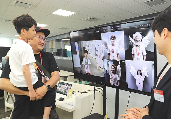롯데온 가족초청행사 참석 가족이 AI프로그램이 그린 그림을 보고 있다. 사진=롯데쇼핑